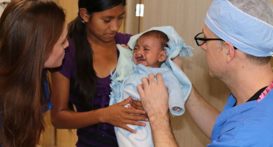 Mission in Guatemala - Dr. Morin viewing infant before operation