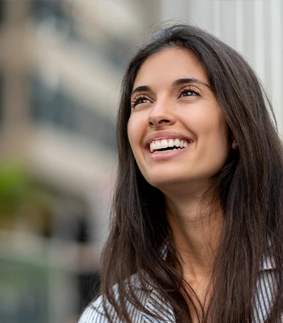 Rhinoplasty Recovery and Aftercare: A young woman smiling outdoors with a bright, natural expression